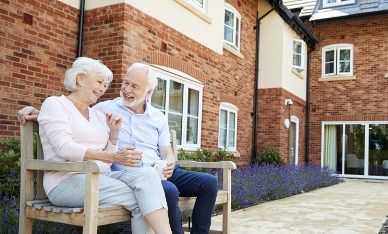 couple sitting in front of house